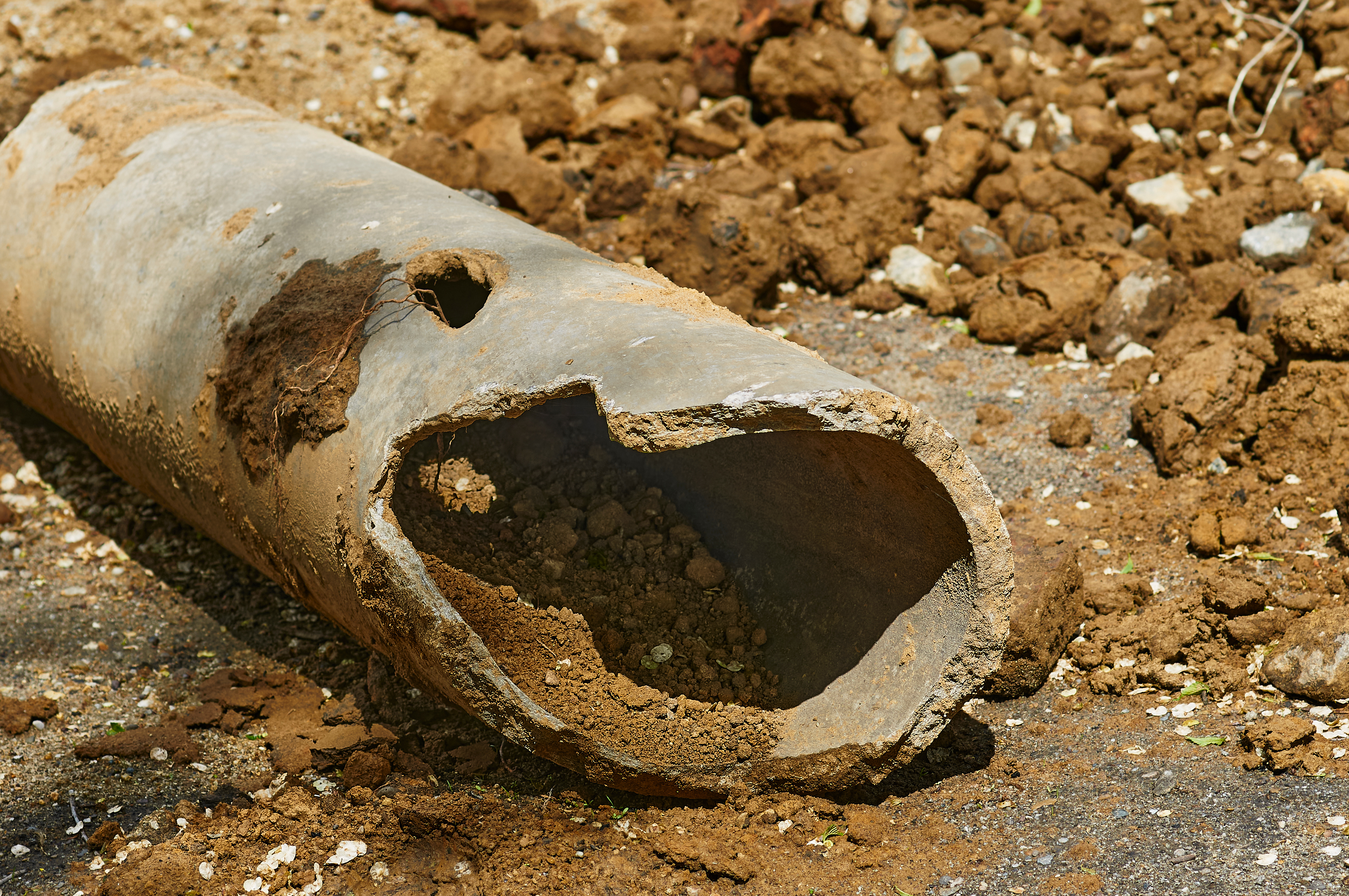 Water leaking from a broken pipe into a flooded excavation trench